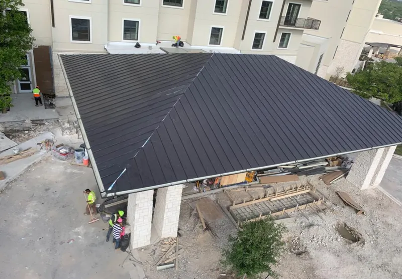 Metal roofing installation team working on a commercial building in Manalapan